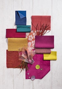 a variety of colorful fabrics and materials laid out on a wooden surface